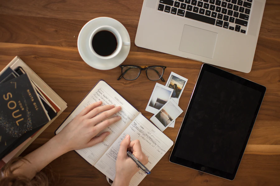 Defter, bilgisayar ve not alan eller